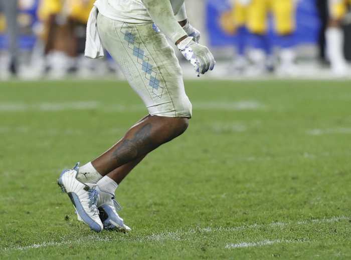 Detailed look at North Carolina Tar Heels linebacker Cedric Gray's white and blue Air Jordan cleats.